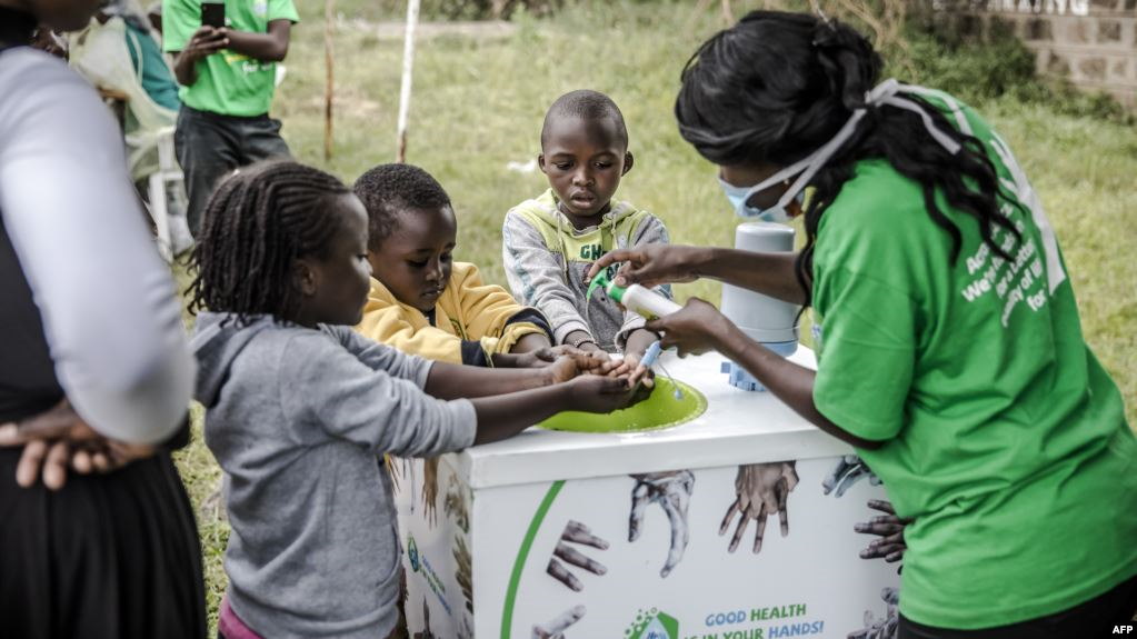 Un travailleur enseigne à plusieurs enfants comment se laver correctement les mains à l'entrée de l'hôpital Mbagathi de Nairobi, au Kenya, le 18 mars 2020. (Photo: LUIS TATO / AFP)